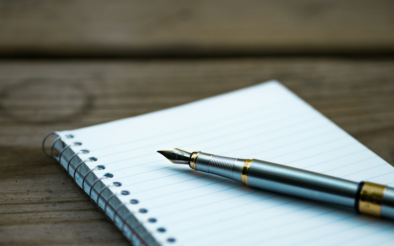 A fountain pen resting on an open notebook